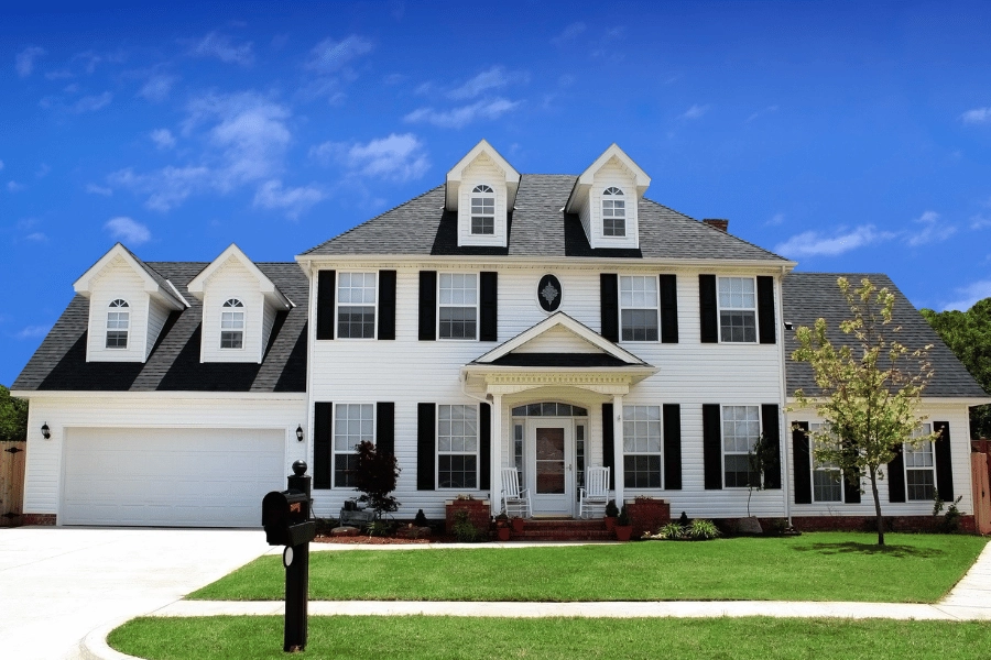 large white house with black shutters and lots of windows
